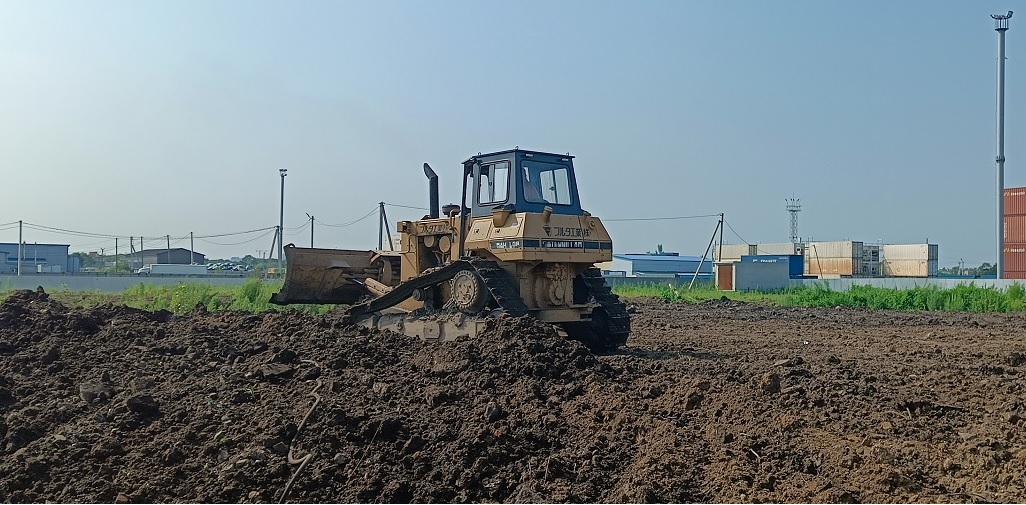 Бульдозер и экскватор роют и копают котлованы в Ордынском